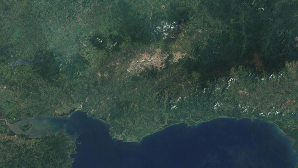 Satellite image of a natural landscape with green forest areas and a body of water, showcasing detailed digital terrain modeling capabilities